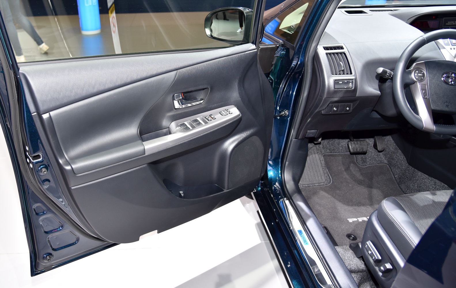 Interior door panel and driver side cabin with controls and seat.