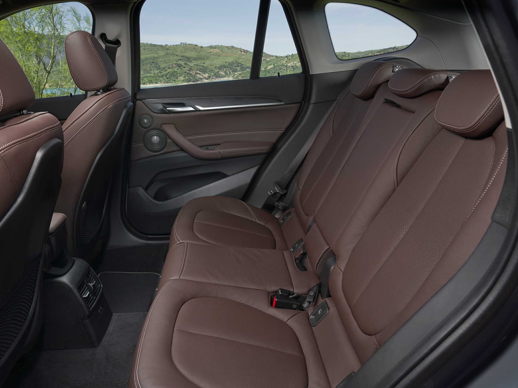Brown leather rear seats with detailed stitching and spacious cabin
