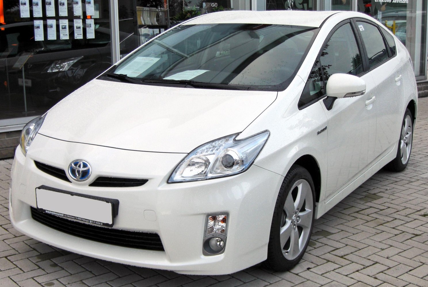 White hybrid sedan with angular headlights and aerodynamic front design
