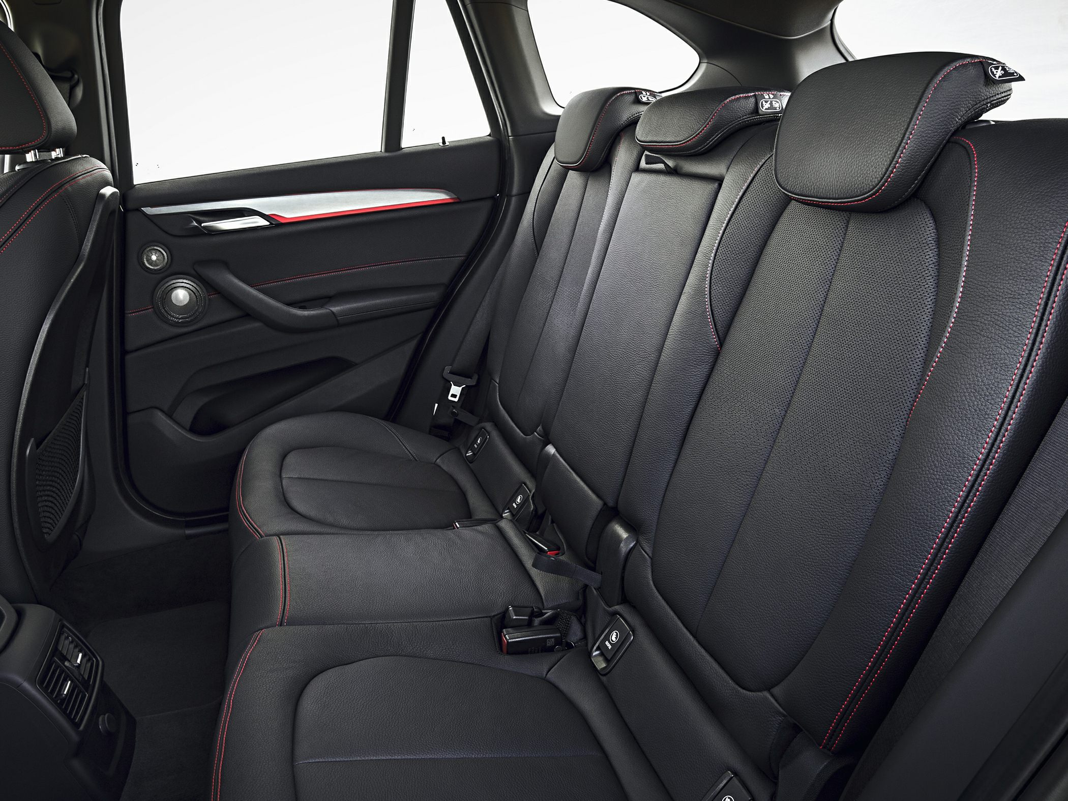 Rear leather seats with red stitching and headrests.