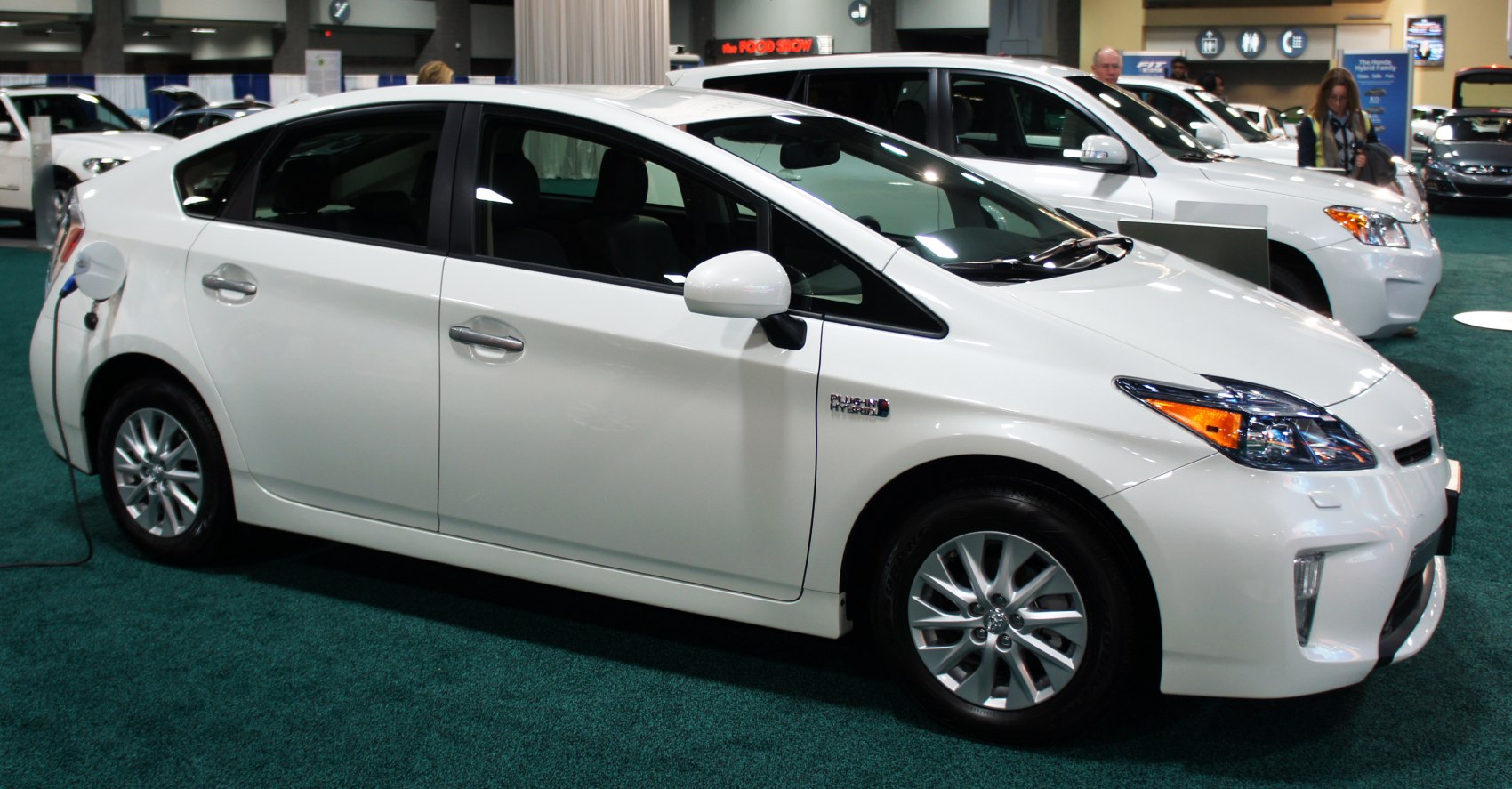 Side view of a white plug-in hybrid car with charging port