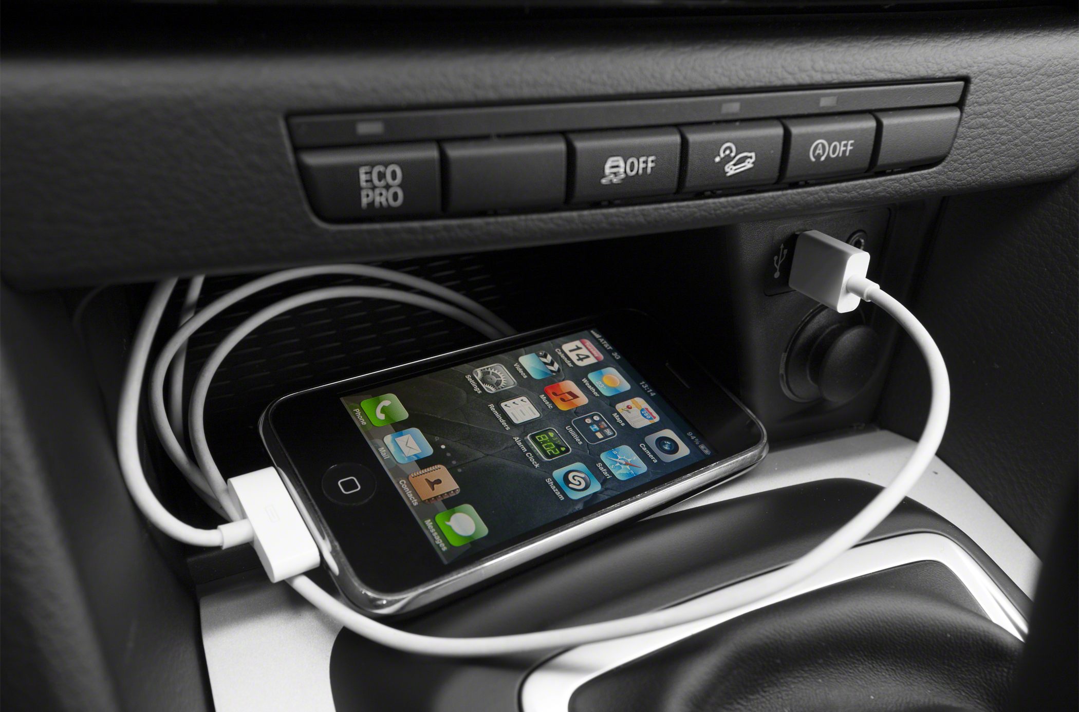 BMW dashboard USB port with connected smartphone cable and control buttons