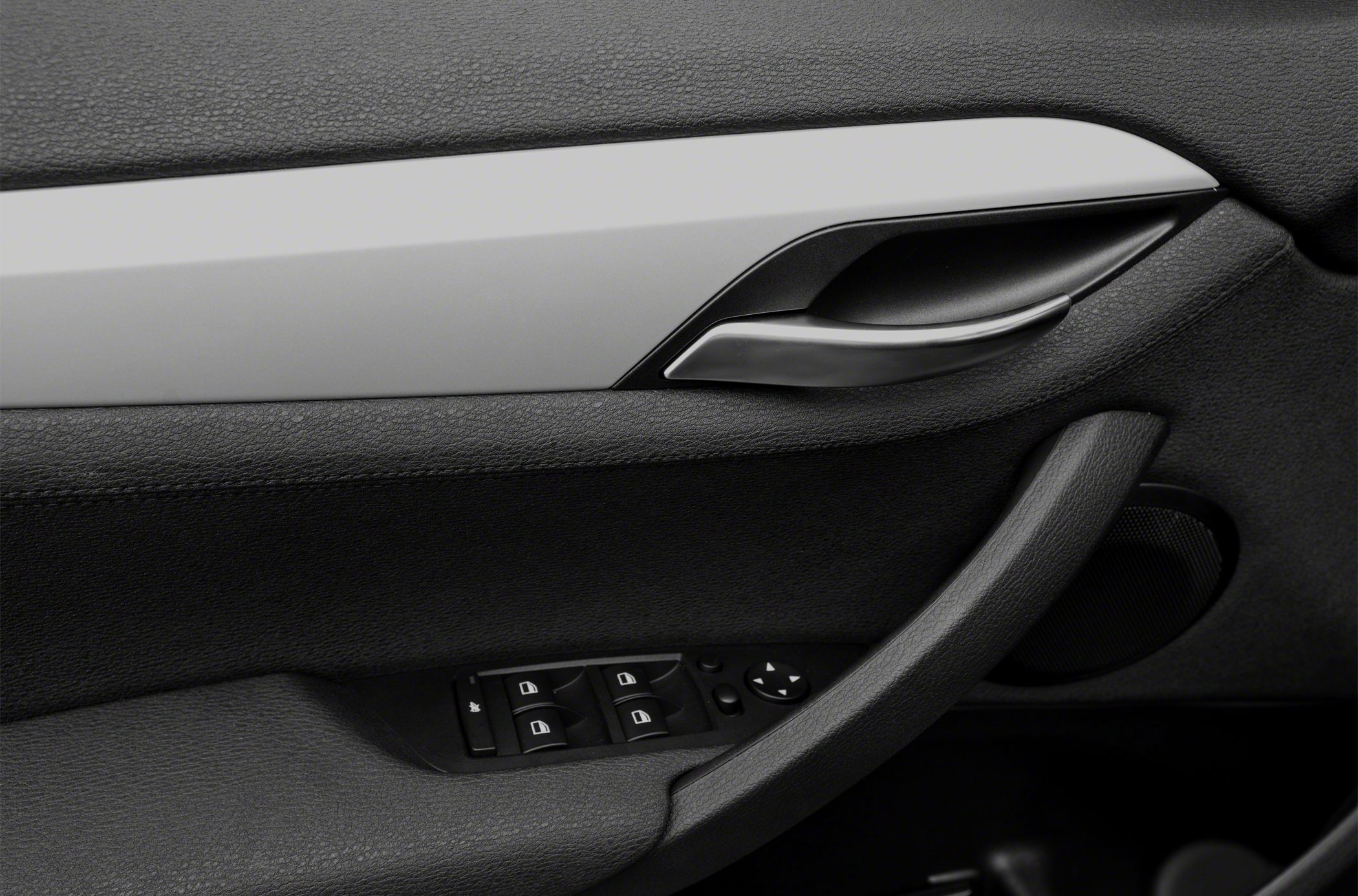 Interior door handle, window controls, and speaker on car door panel
