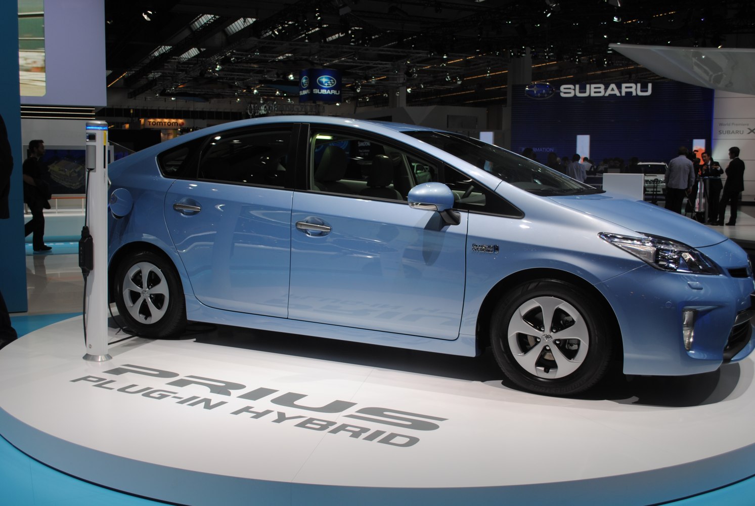 Blue Prius Plugin Hybrid side view with charging station