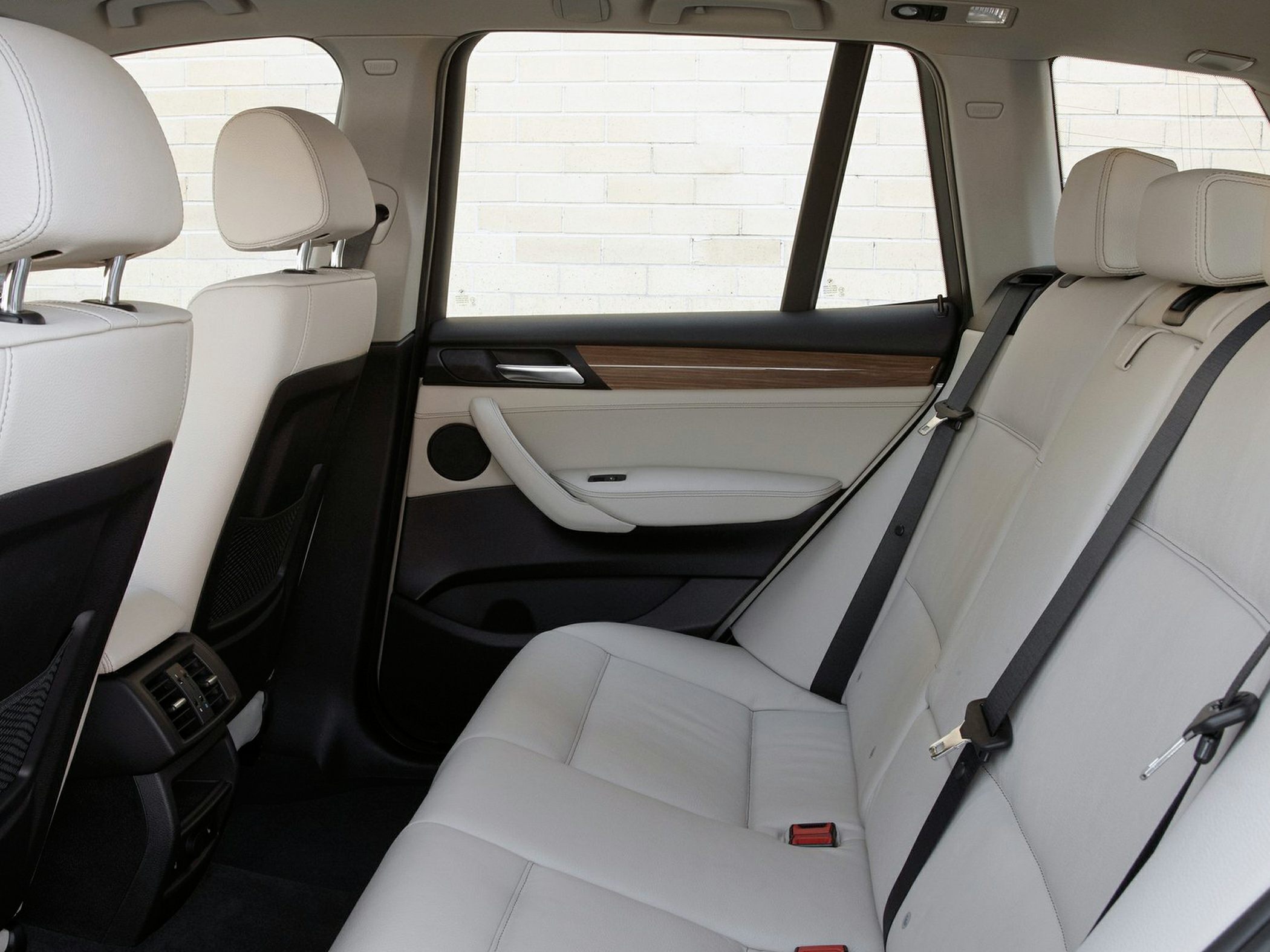 Rear beige leather seats with wood trim and seat belts