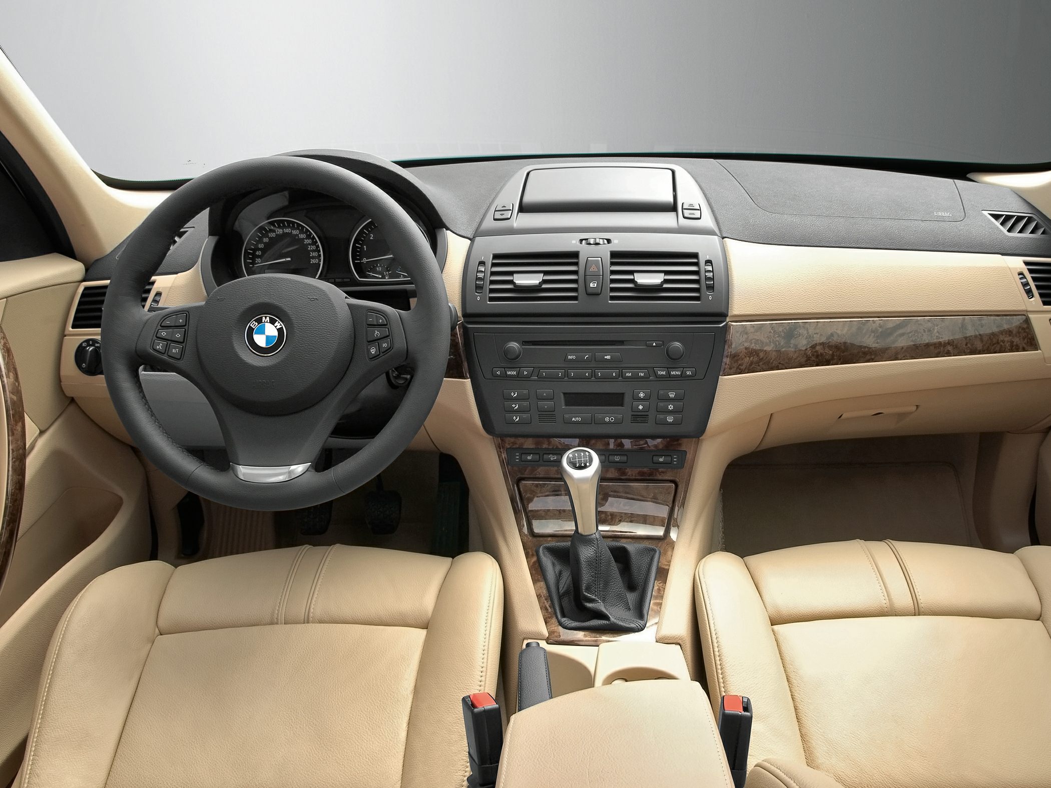 Beige leather interior with manual transmission and wood trim dashboard