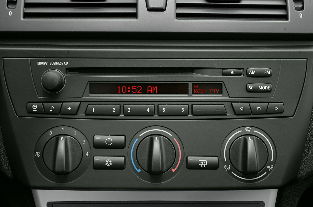 Close-up of car audio system and manual climate control knobs