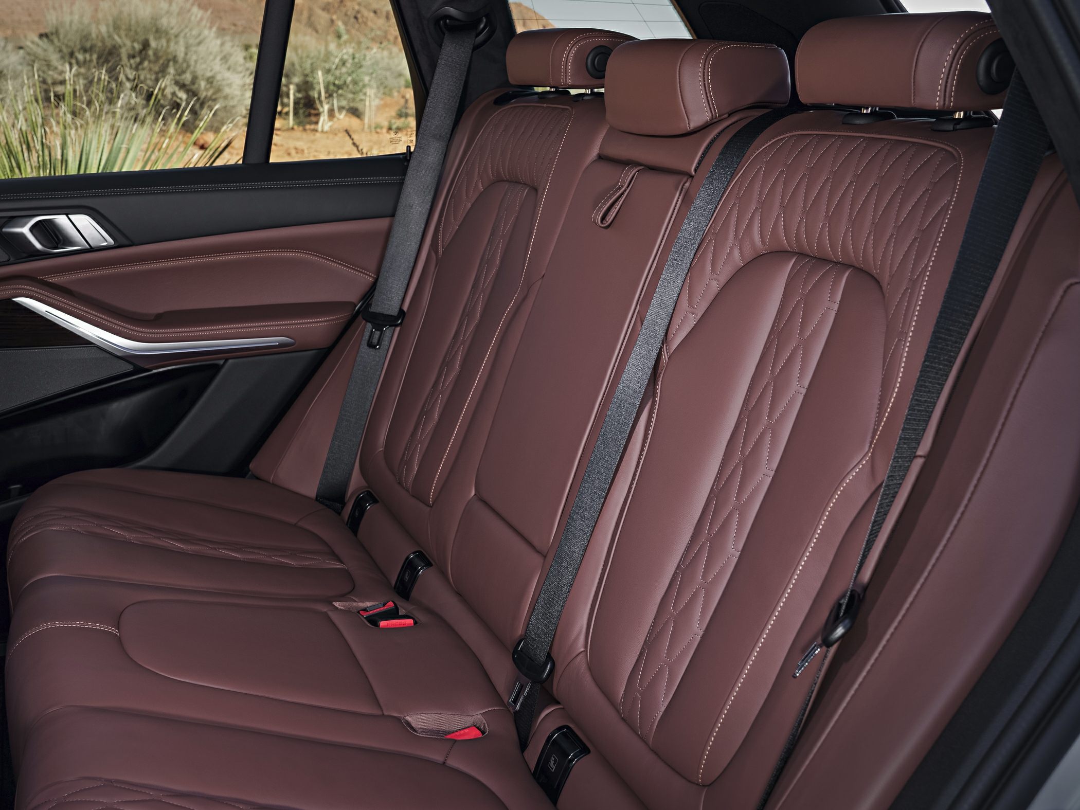 Quilted brown leather rear seats with seat belts and premium stitching.