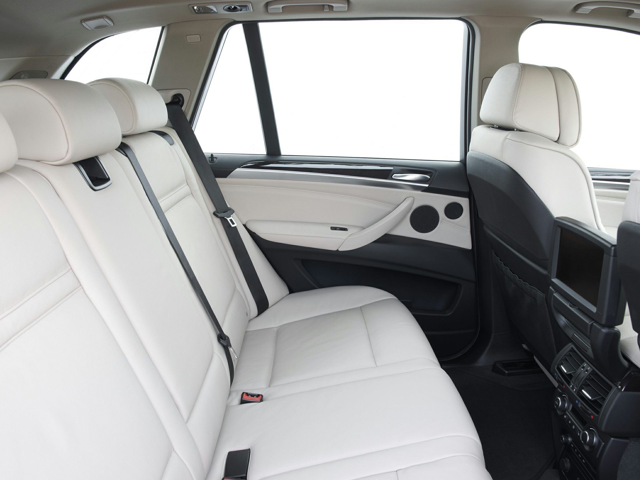 Rear seat interior with beige leather upholstery and rear entertainment screen