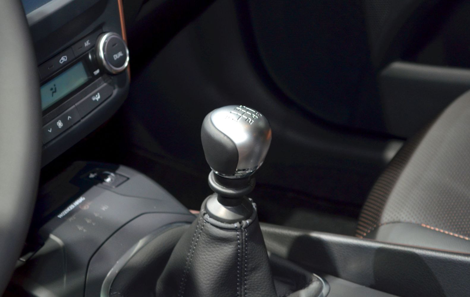 Manual gear shift lever with leather boot in car interior
