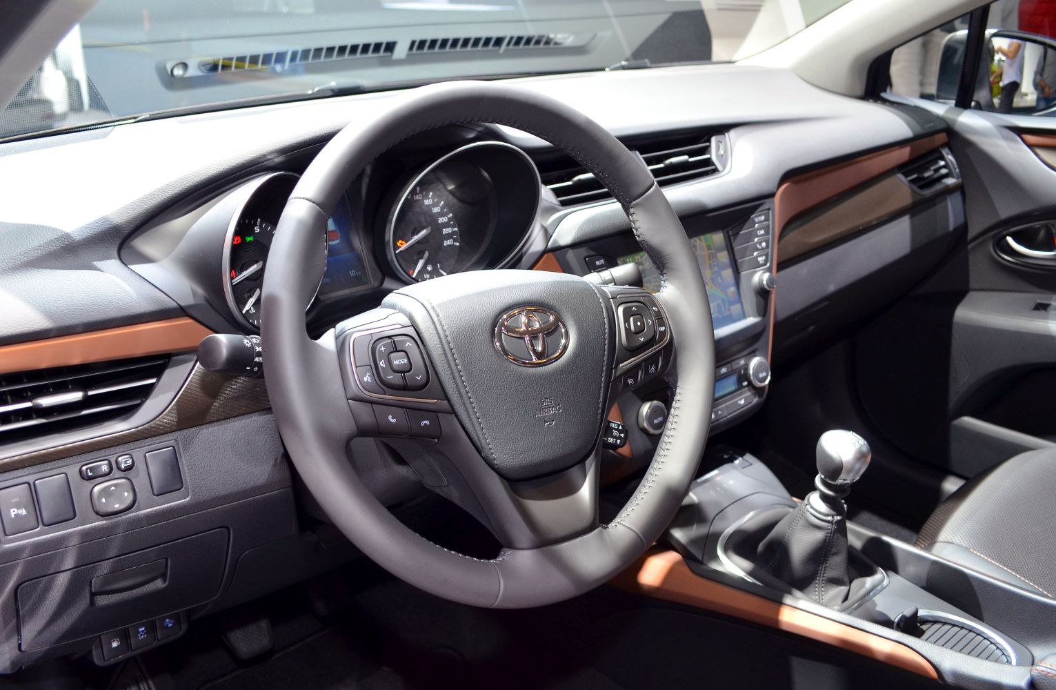 Steering wheel, dashboard with instrument cluster, and manual gear shift.