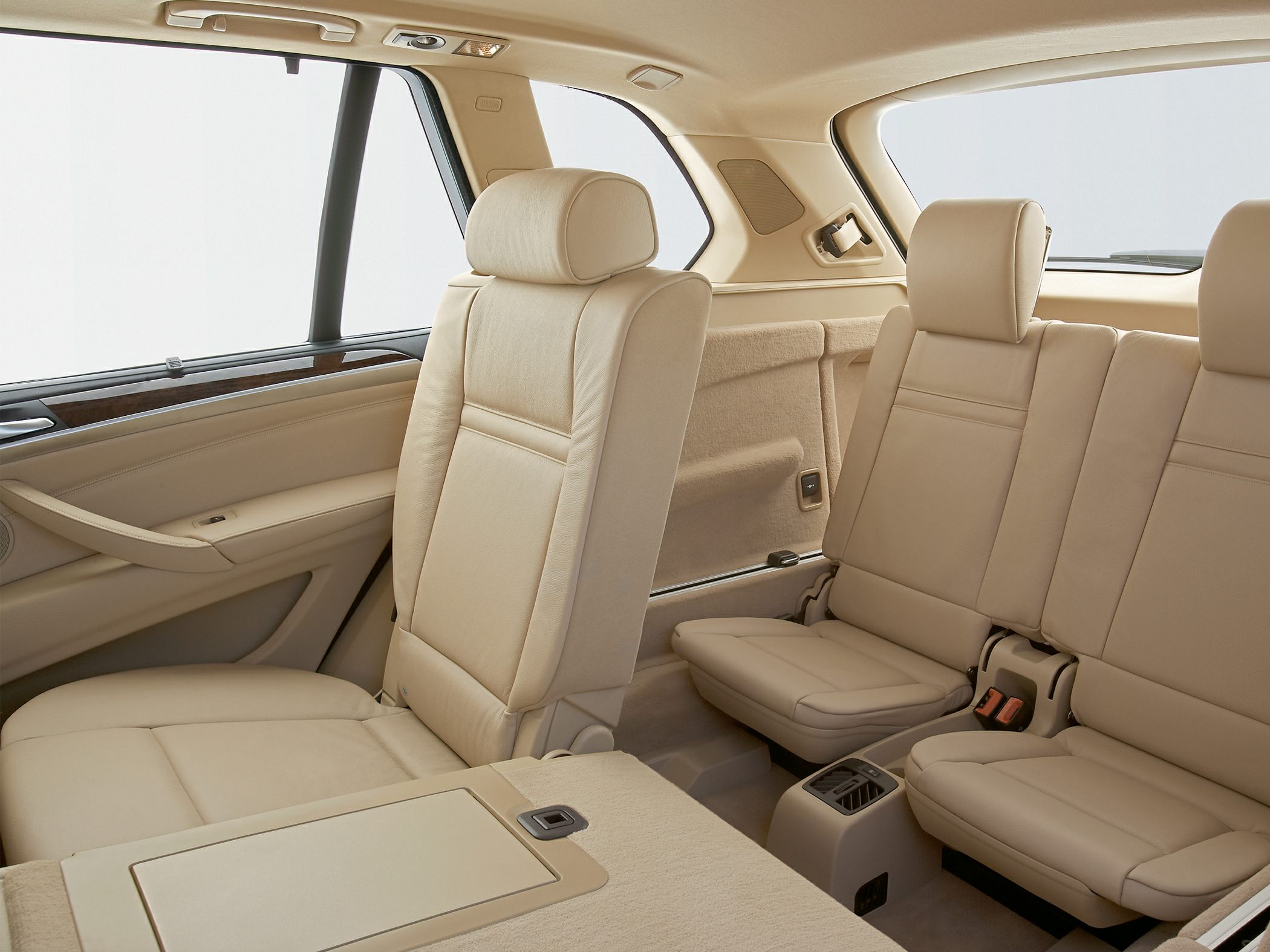 Beige leather third row seating with wood trim in a spacious SUV interior