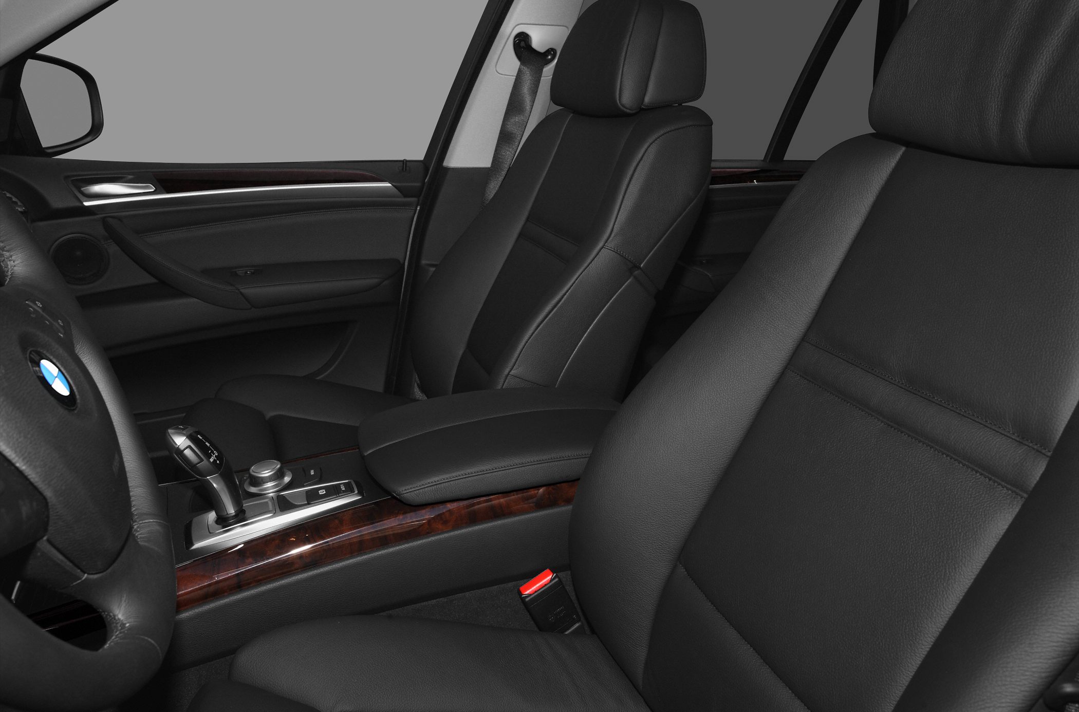 Black leather front seats and wood trim center console in luxury SUV interior