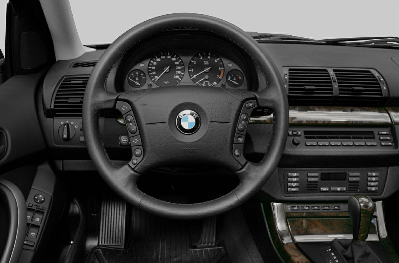 Steering wheel and dashboard with instrument cluster and center console controls.