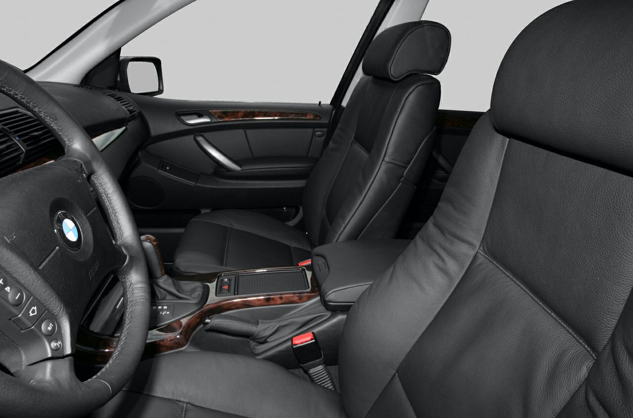 Black leather seats and wood trim interior with steering wheel close-up