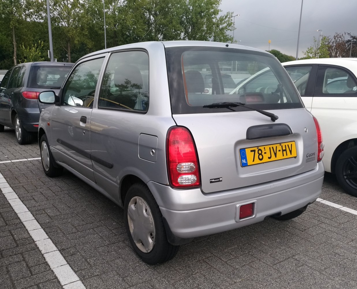 Compact hatchback rear with vertical tail lights and rear wiper.