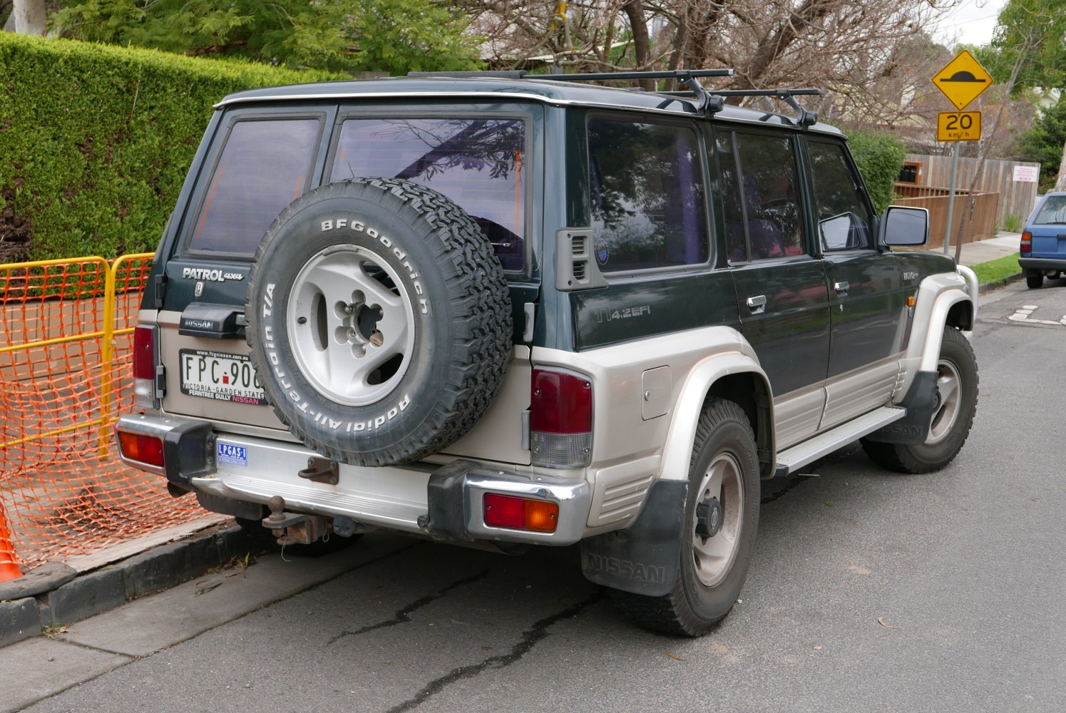 Rear and side view of 5-door SUV with roof racks and spare tire