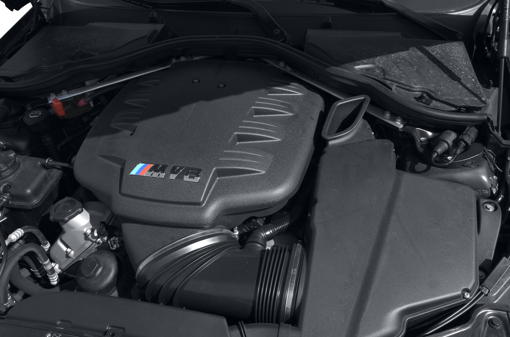 View of a V8 engine bay with engine cover and intake components