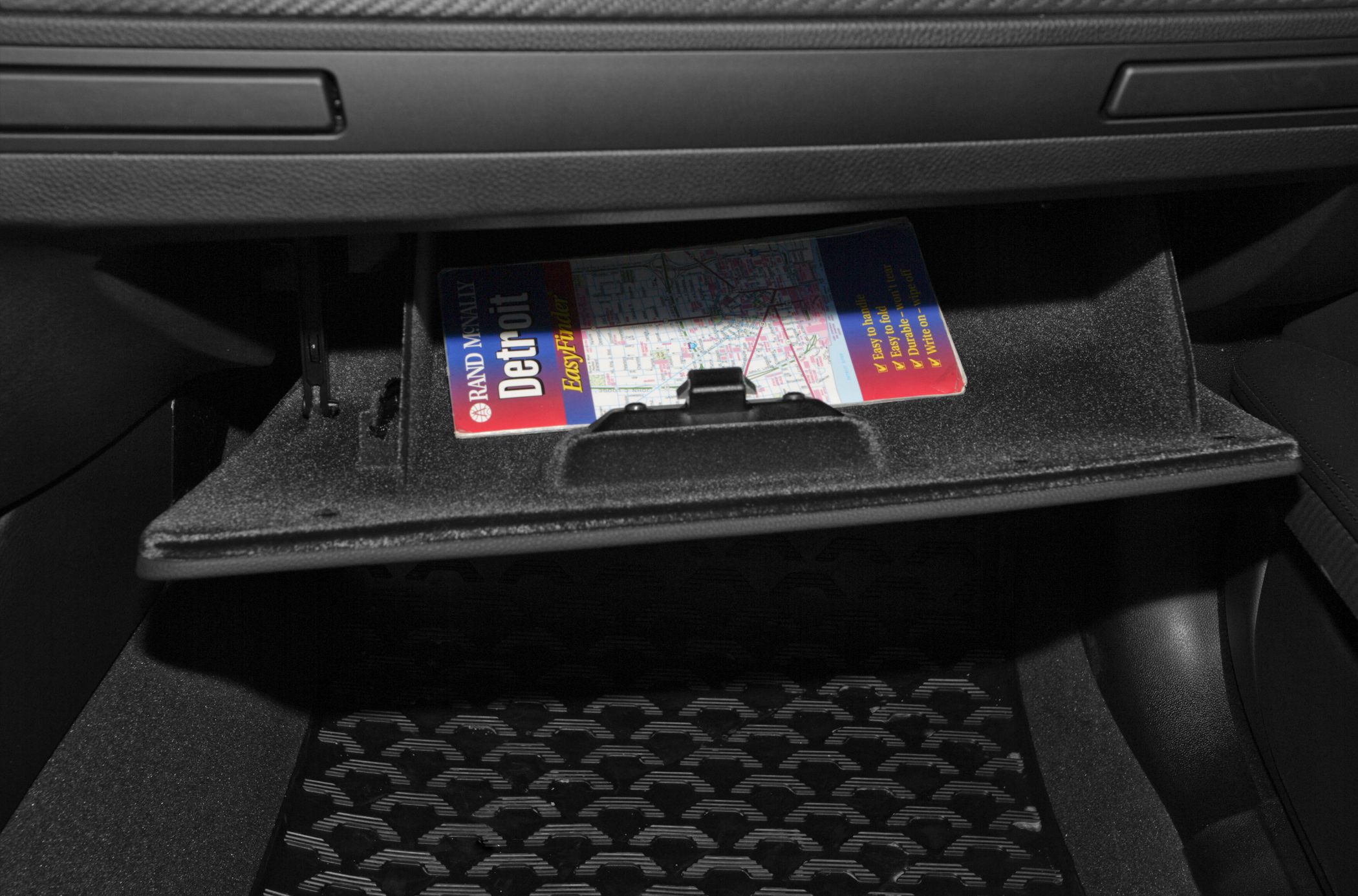 Open glovebox compartment with a map inside