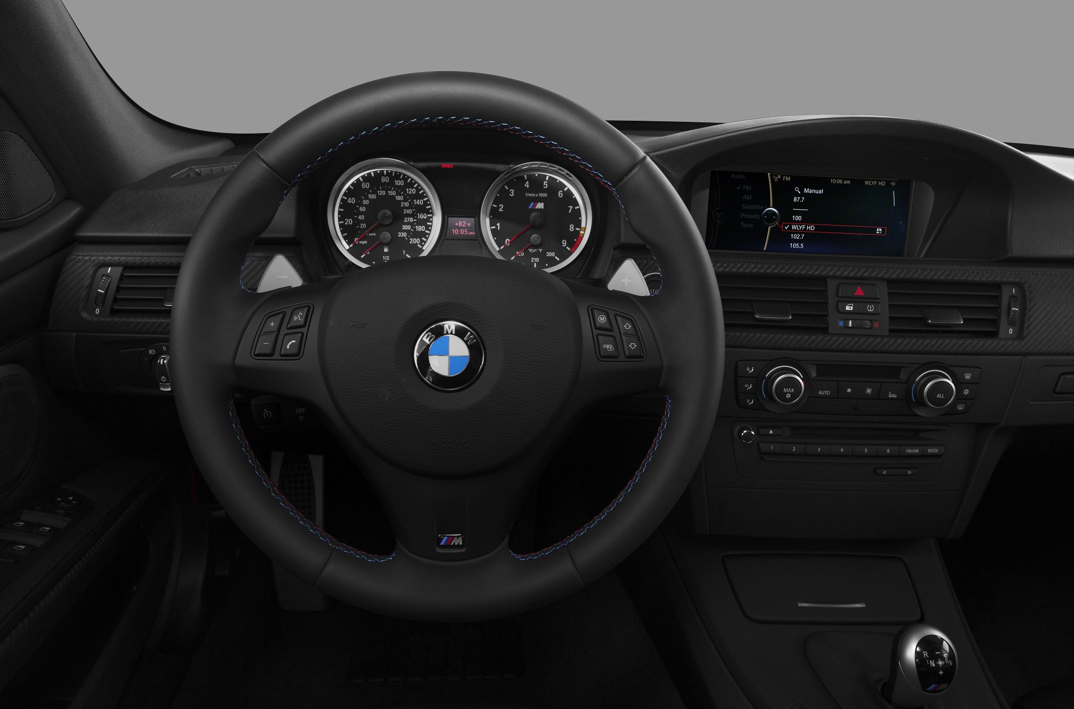 Steering wheel with M badge, instrument cluster, dashboard controls.