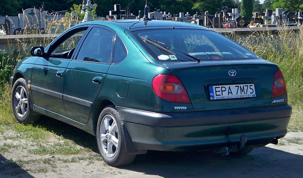 Rear view of a green hatchback with tail lights and rear window wiper
