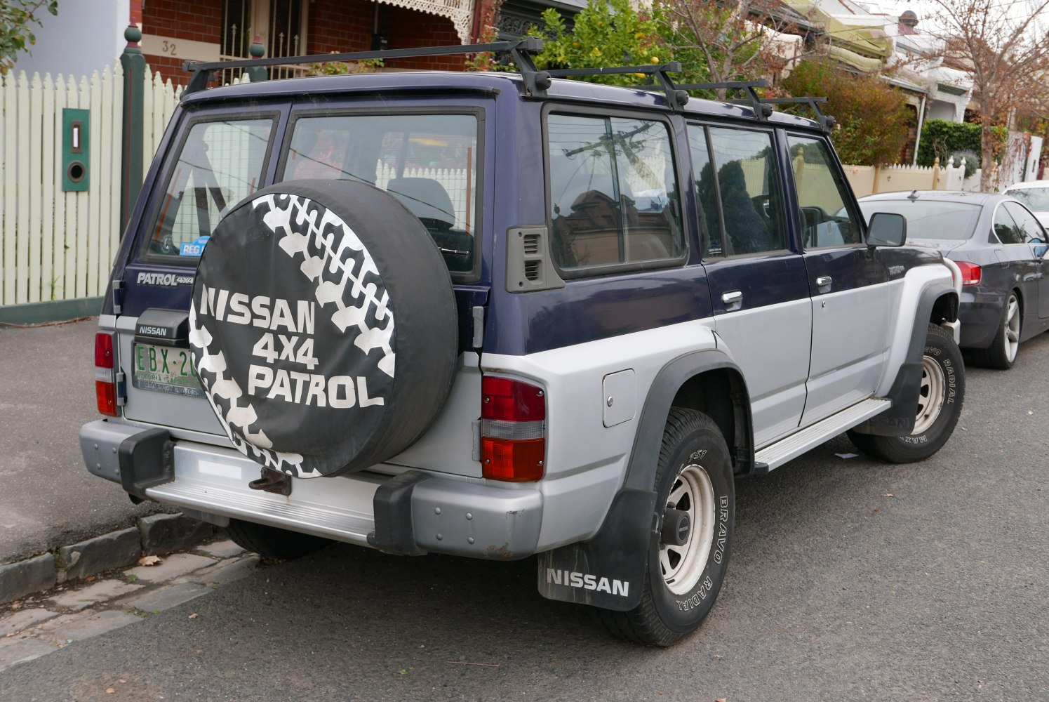 Rear view of SUV with spare wheel cover and roof racks