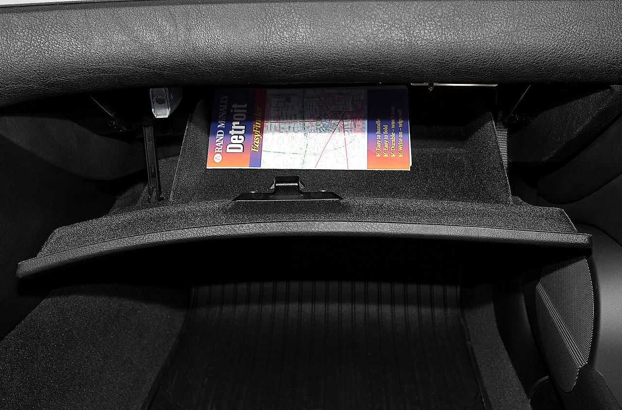 Open glove box compartment with map inside