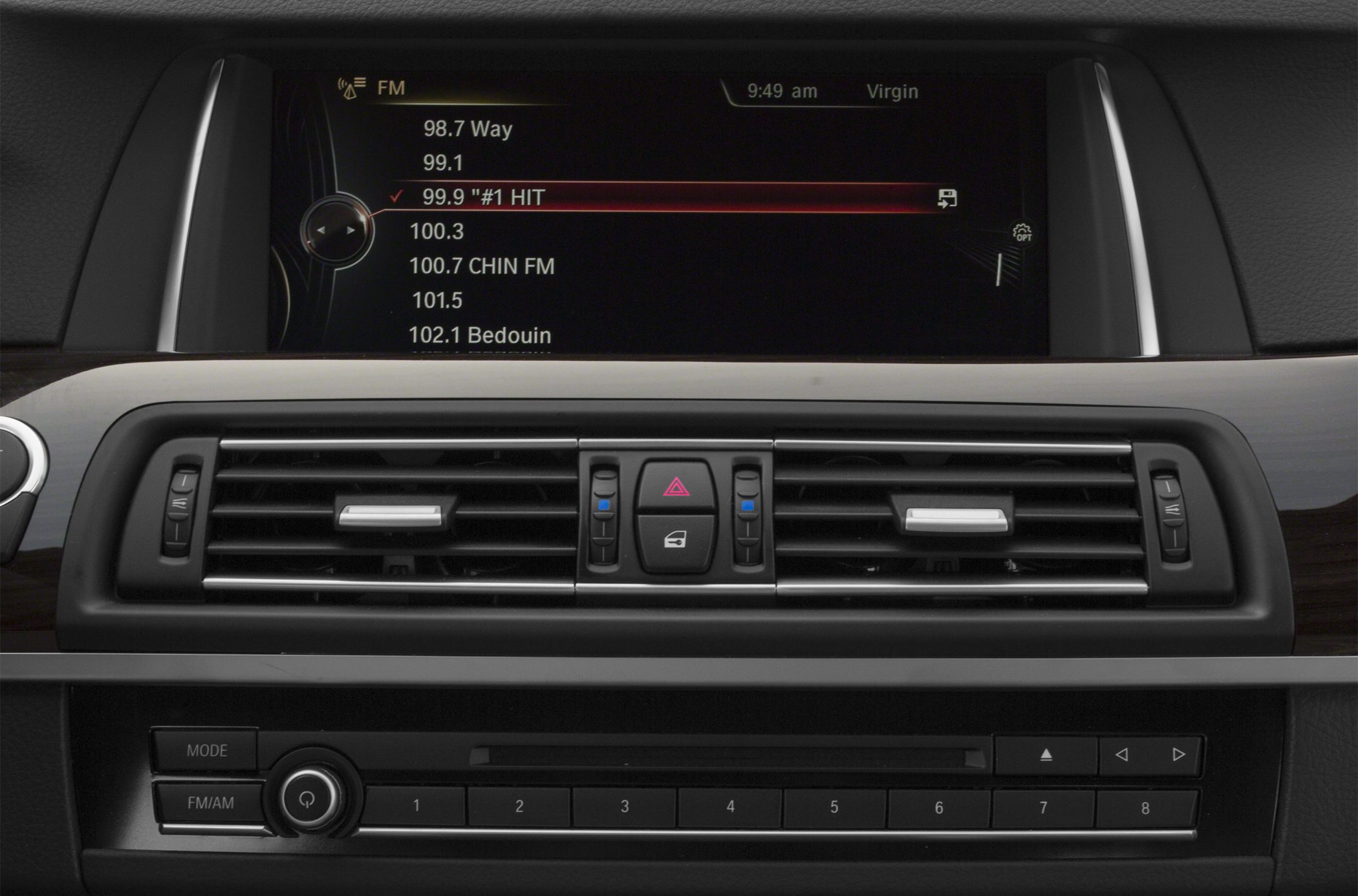 Infotainment screen displaying FM radio with central air vents and control buttons.