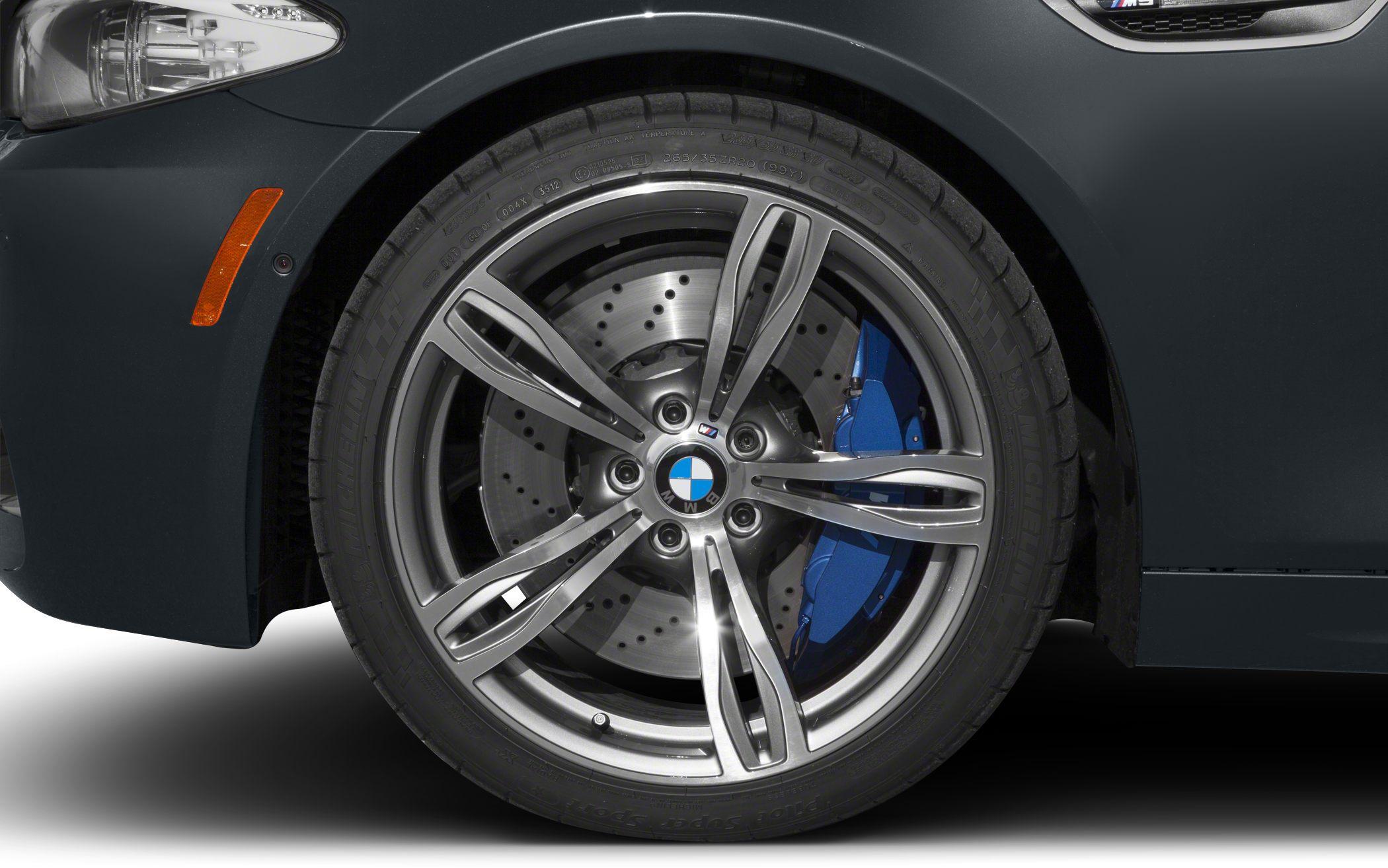 Close-up of front alloy wheel with blue brake caliper and drilled brake disc