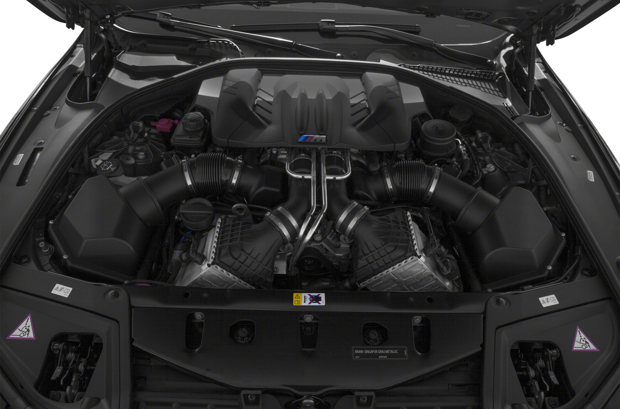 High-performance V8 turbo engine bay with twin turbocharger piping and engine cover.