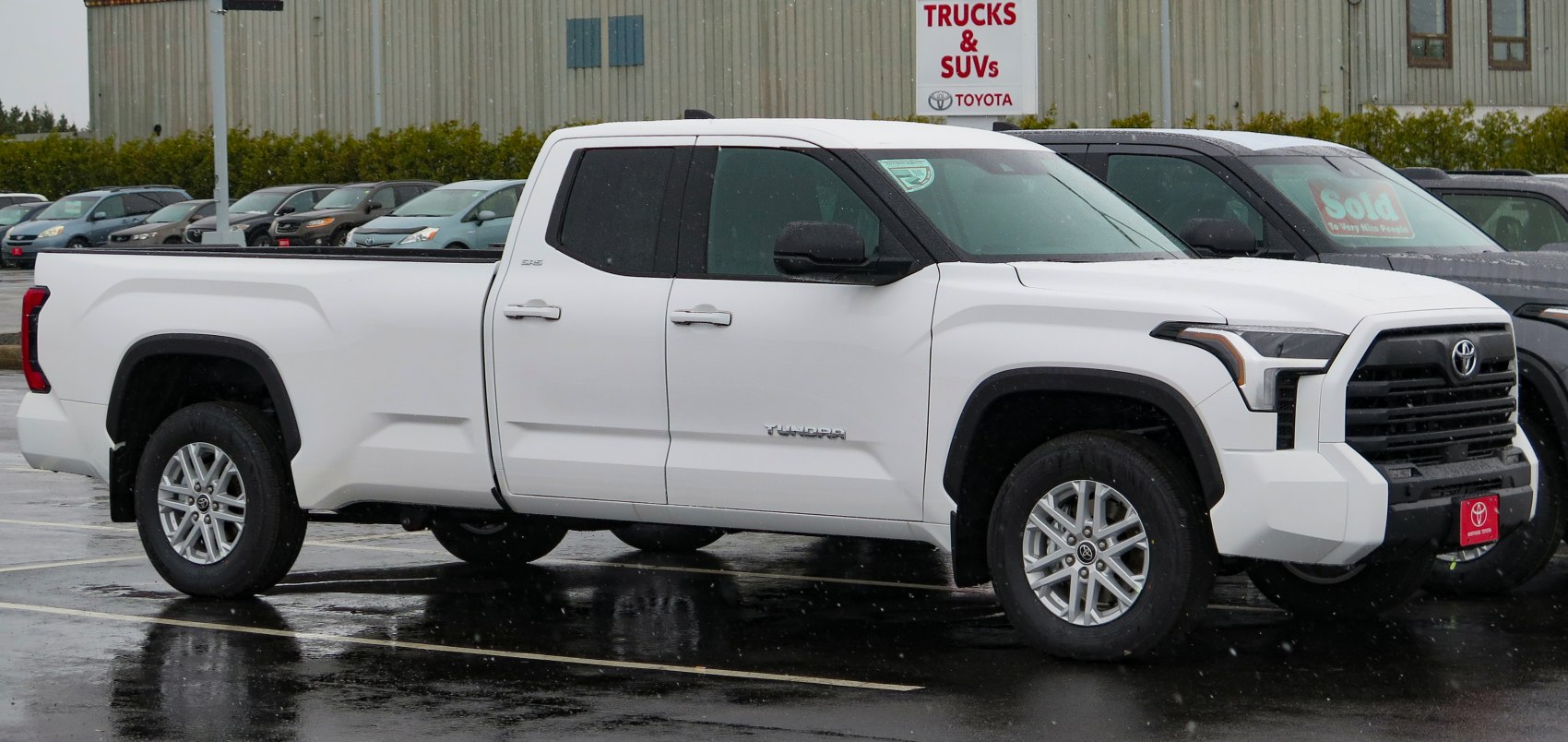 Side profile of white double cab pickup with long bed