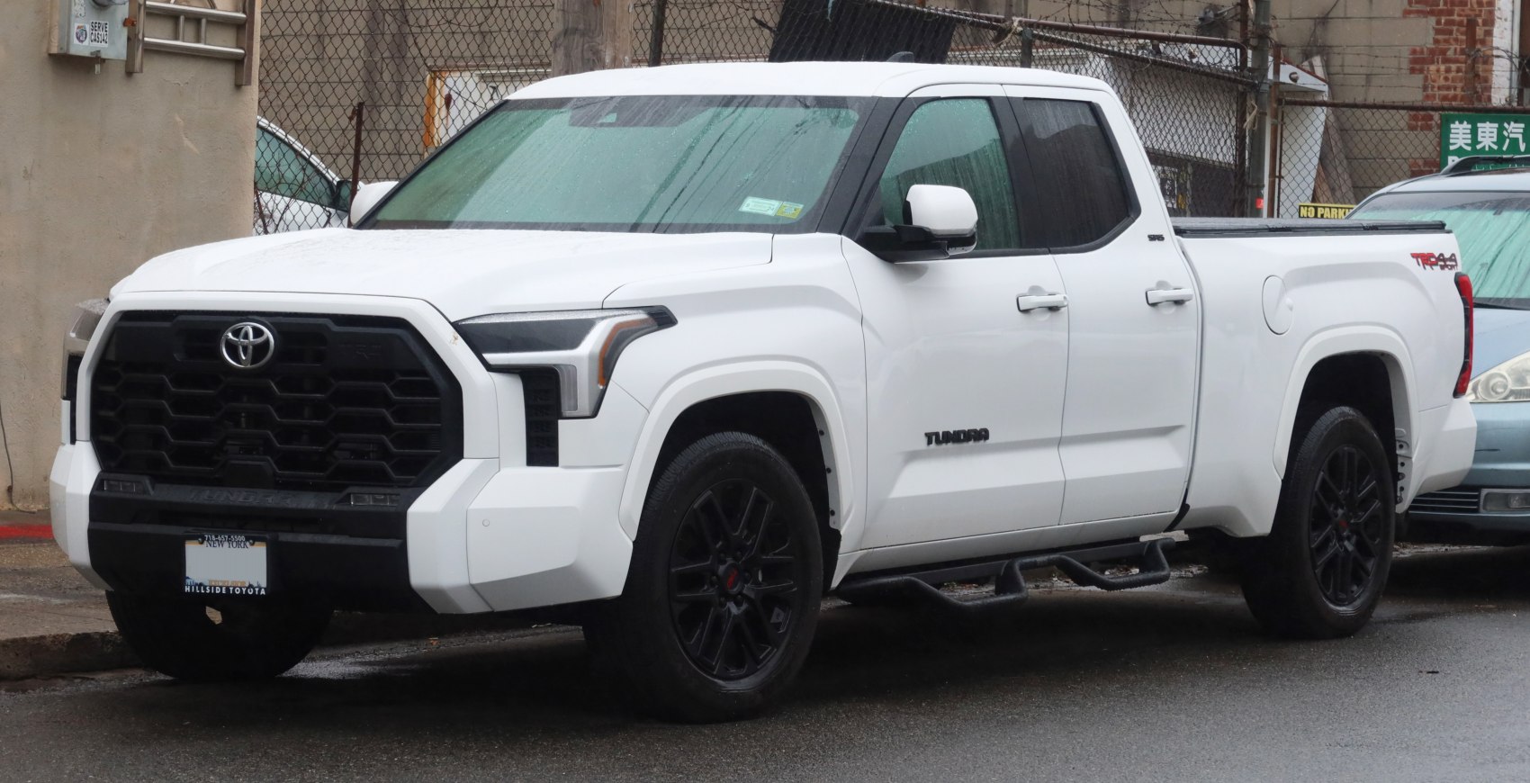 White double cab truck with bold black grille and black wheels