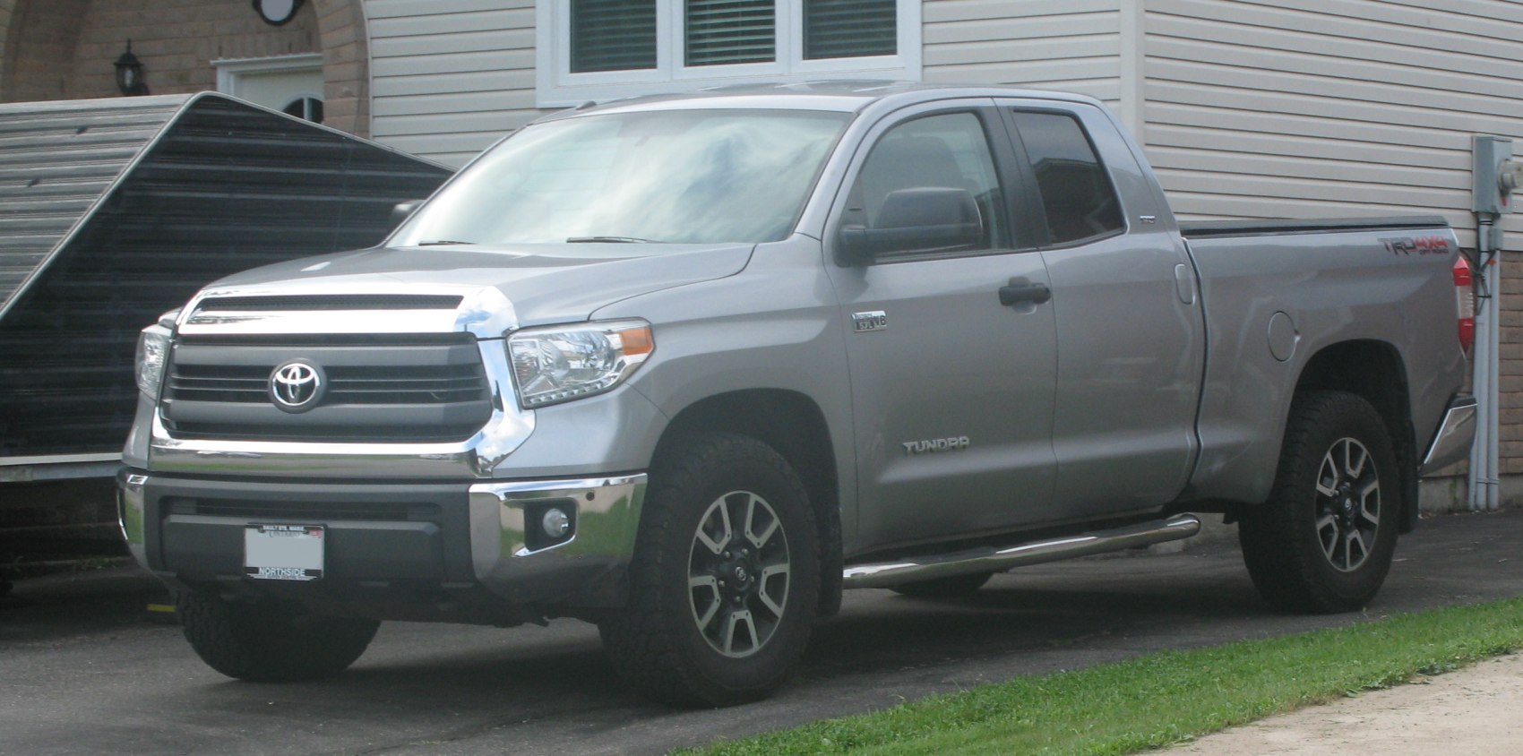 Front side view of pickup truck with chrome grille and alloy wheels