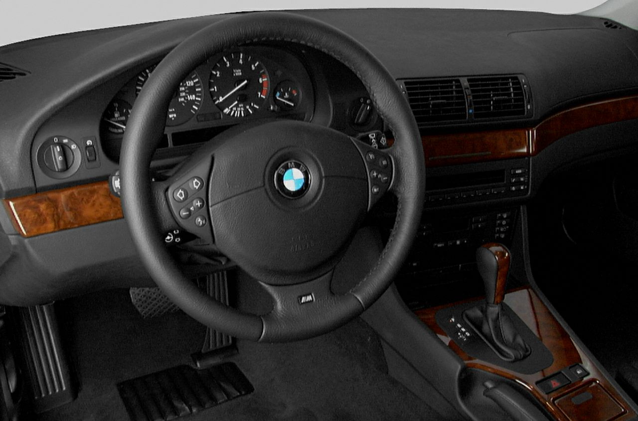 Leather-wrapped steering wheel and wood trim interior with analog gauges