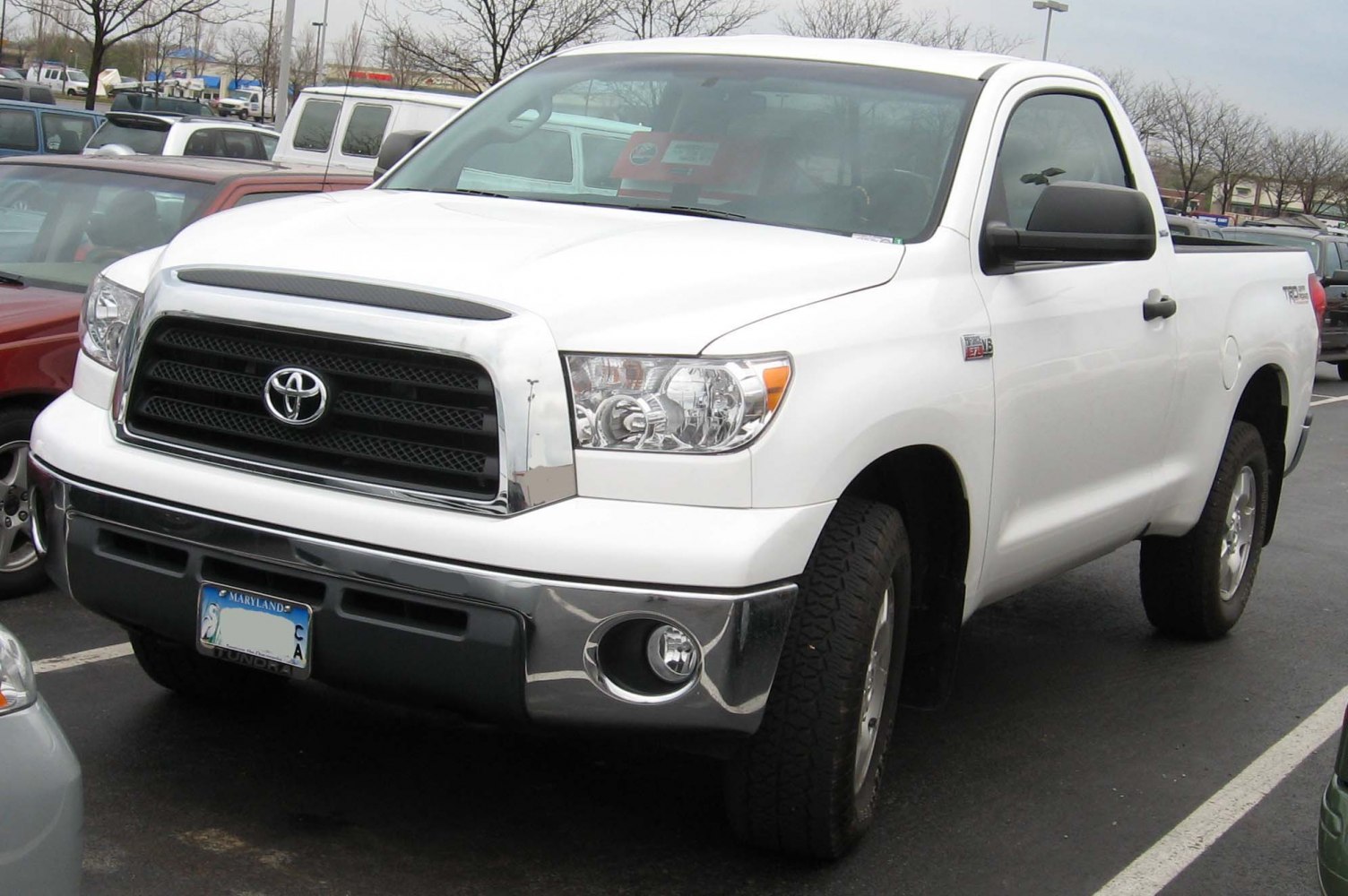 Front view of white pickup with prominent grille and headlights