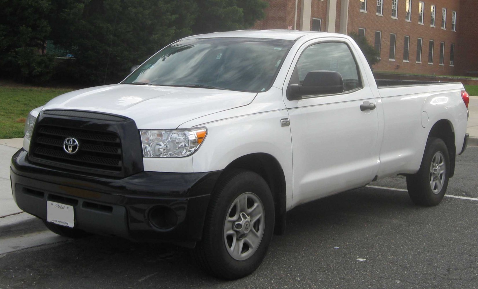 White pickup with black front grille and bumper, single cab design