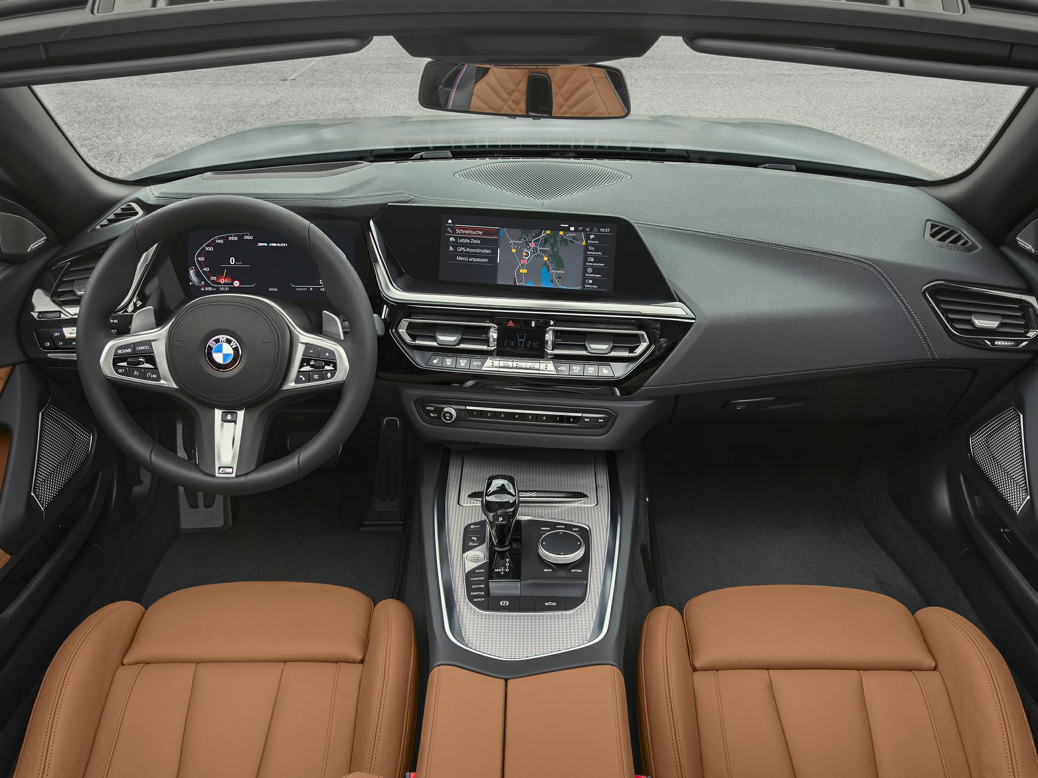 Modern digital dashboard and center console with brown leather seats.