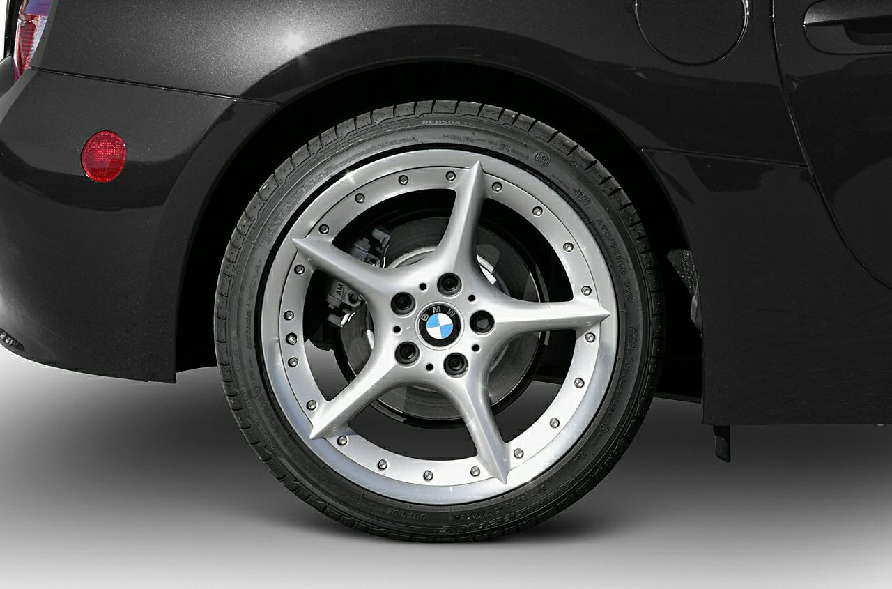 Close-up of five-spoke alloy rear wheel and tire tread.