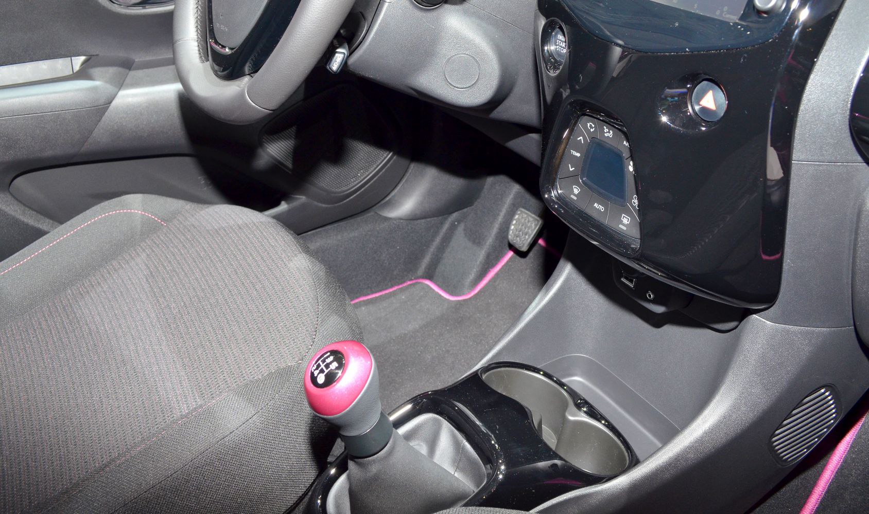 Manual gearshift with pink knob and digital climate controls