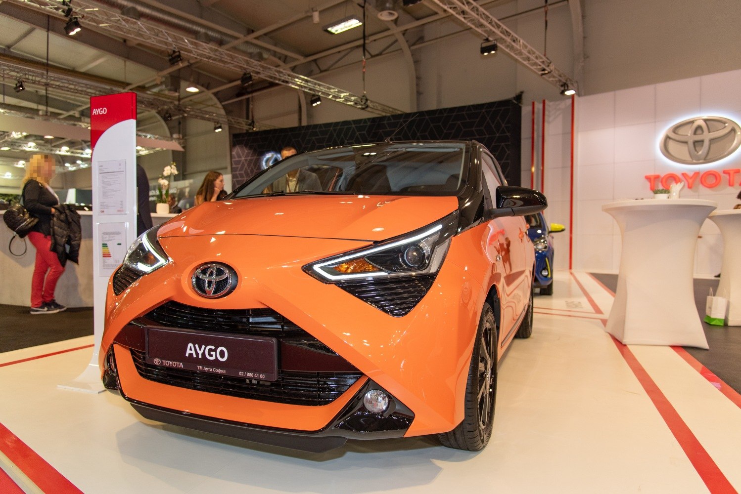 Front exterior with sharp headlights and bold grille in bright orange