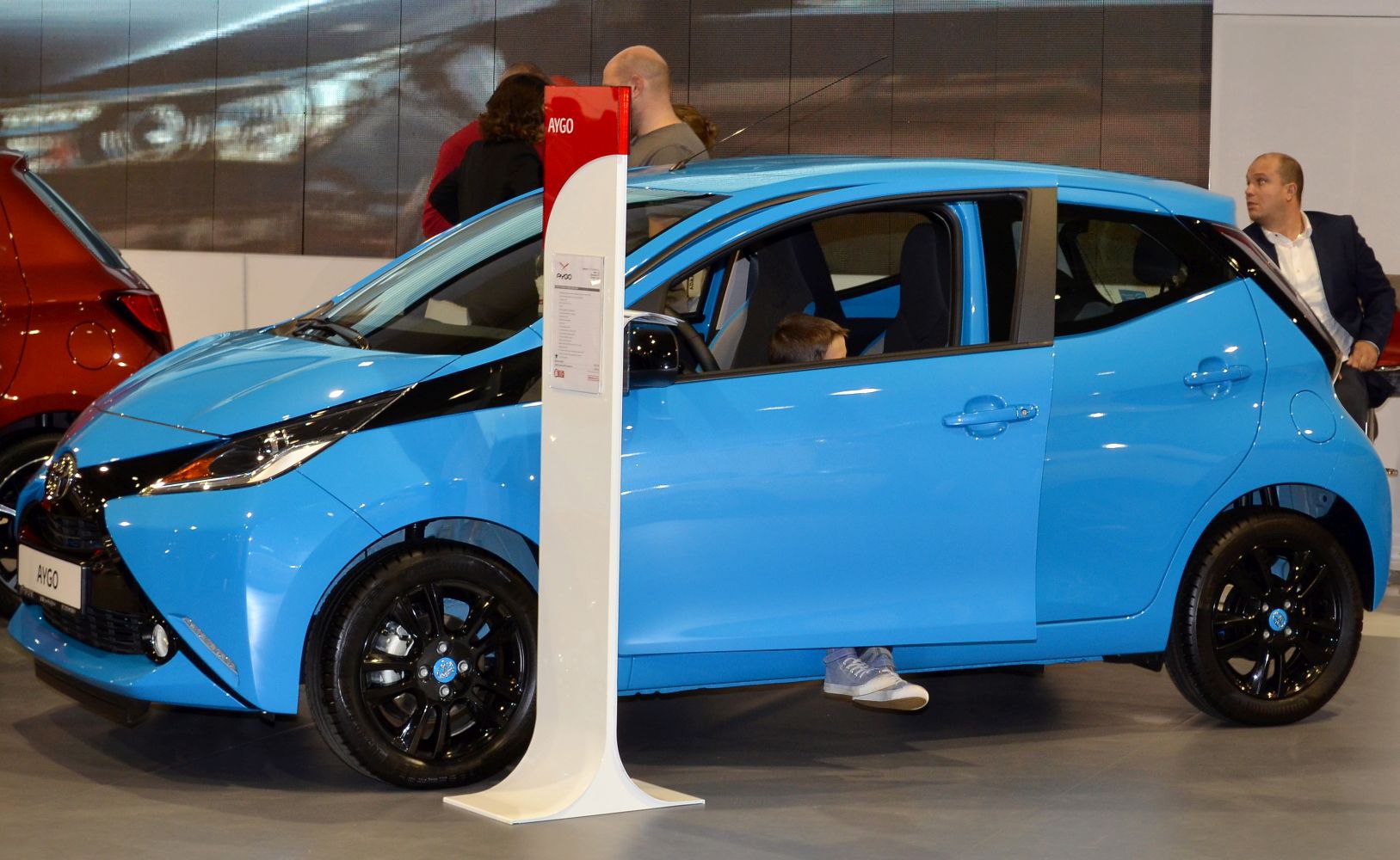 Blue compact hatchback with black alloy wheels and front side visible