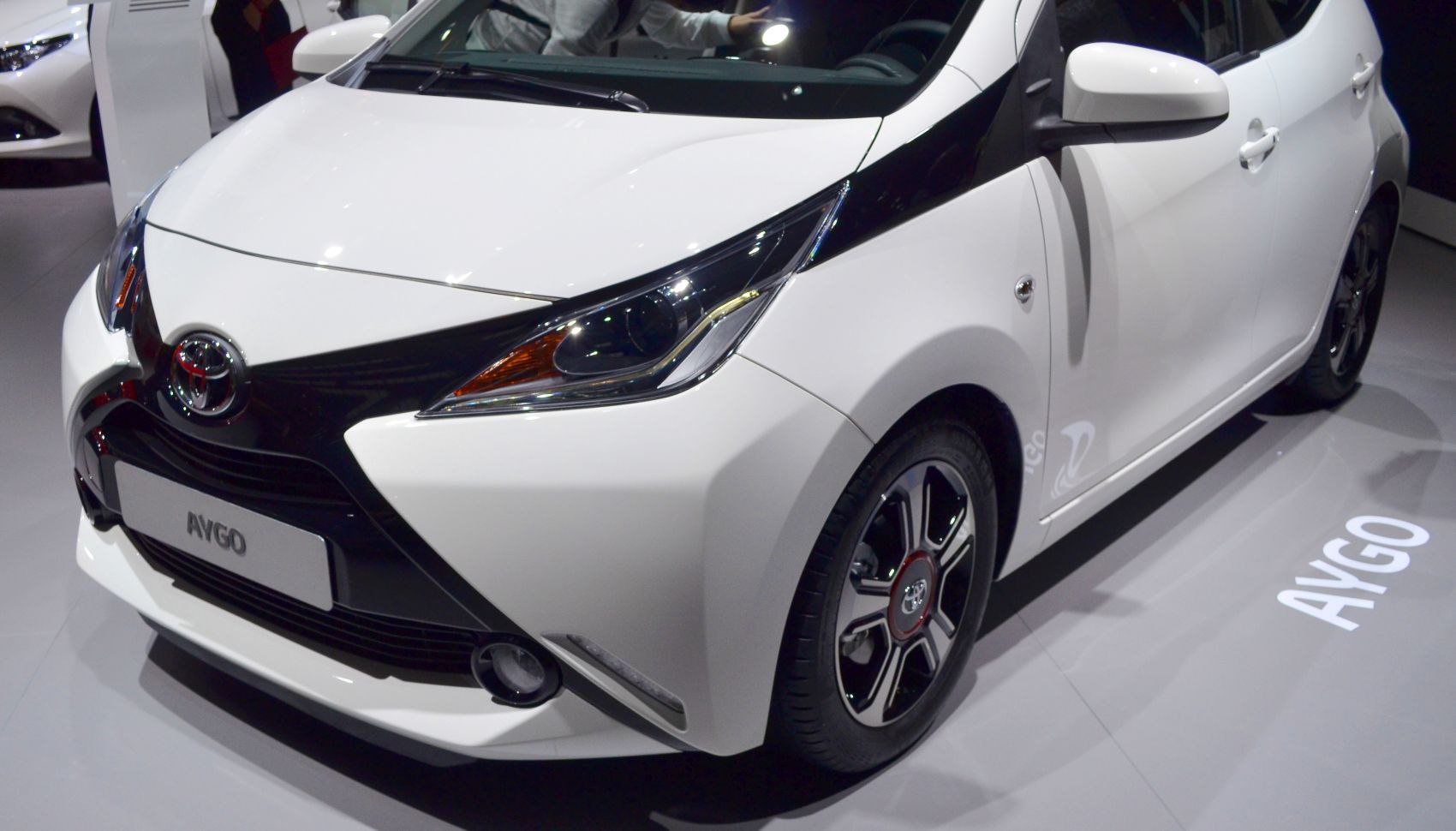 Close-up of distinctive headlight, black front bumper, and alloy wheel design