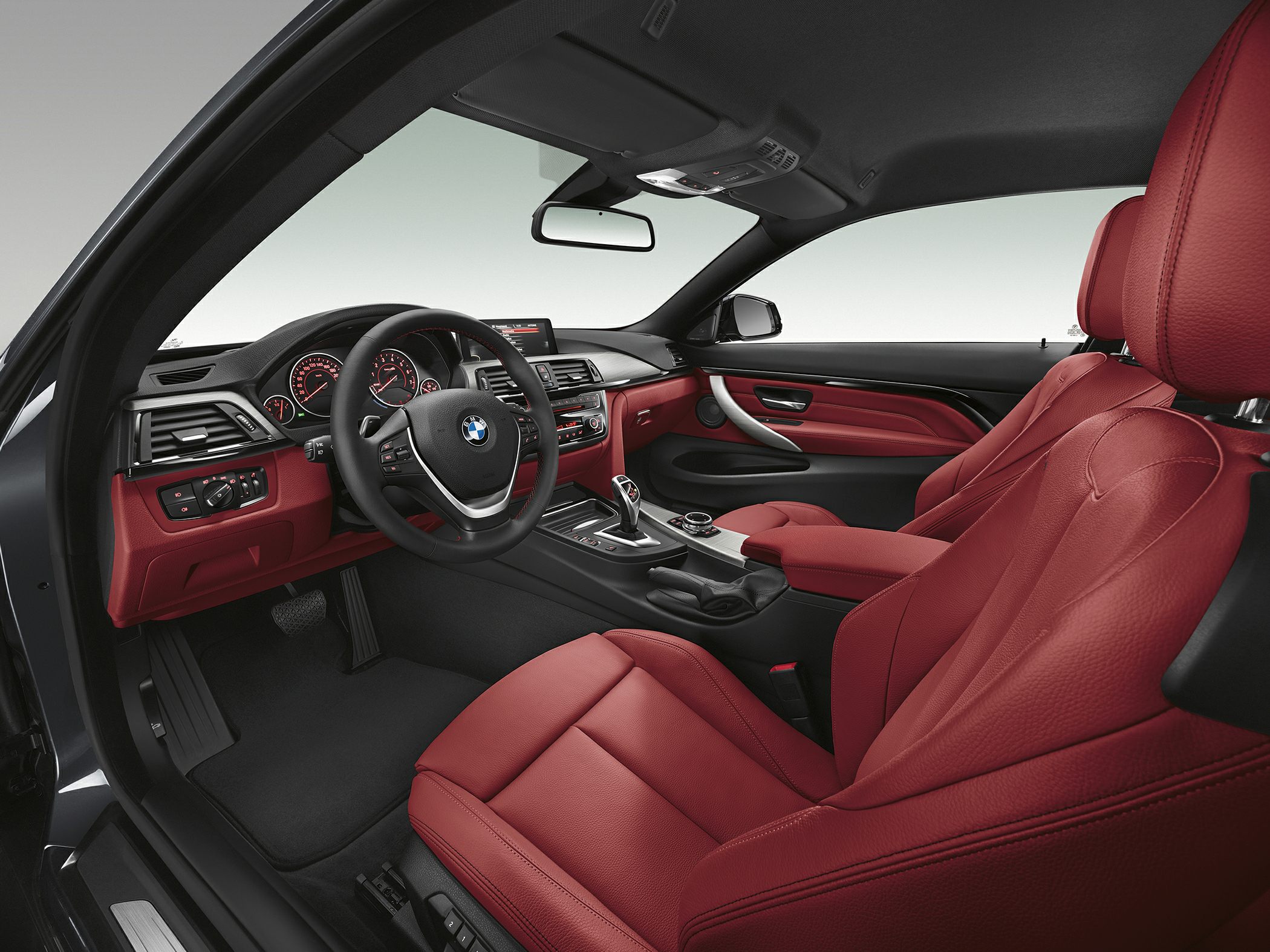 Red leather seats and modern dashboard interior with central console and steering wheel