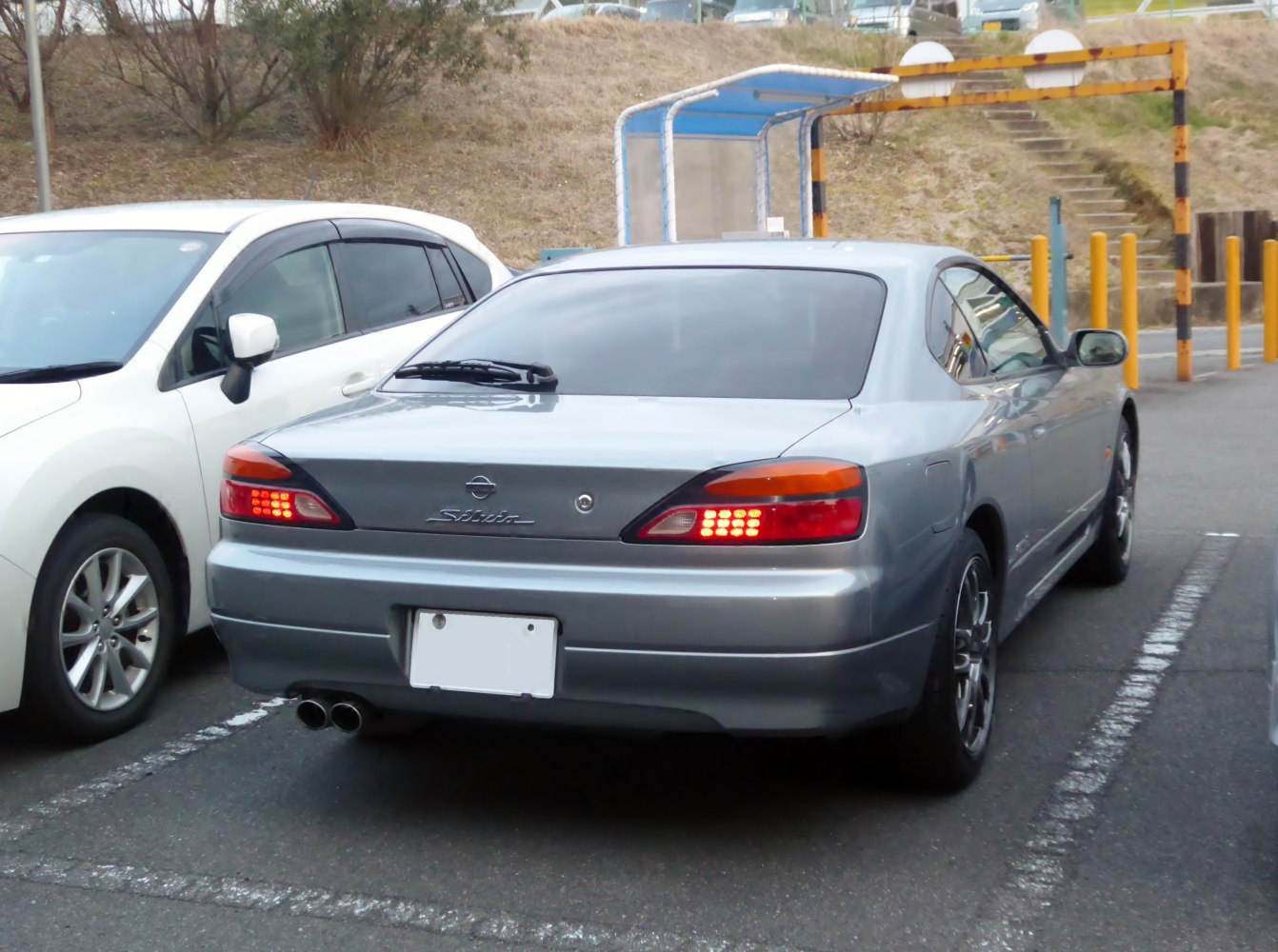 Rear view of sleek coupe with LED tail lights and dual exhaust