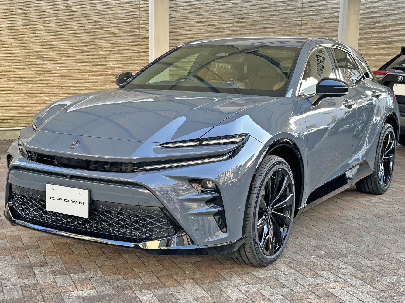 Slim LED headlights and black multi-spoke alloy wheels on a modern sedan.