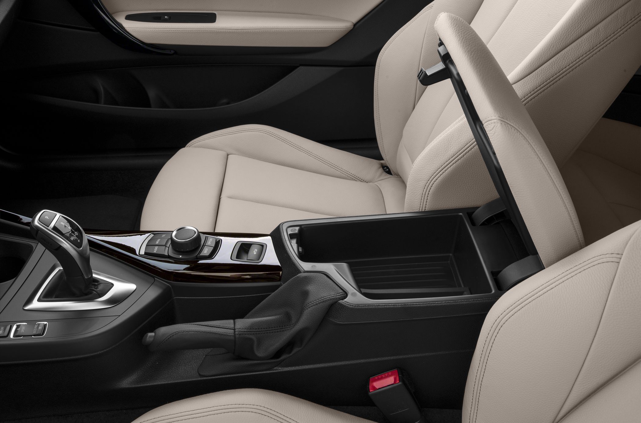 BMW convertible interior with beige leather seats and open center console storage