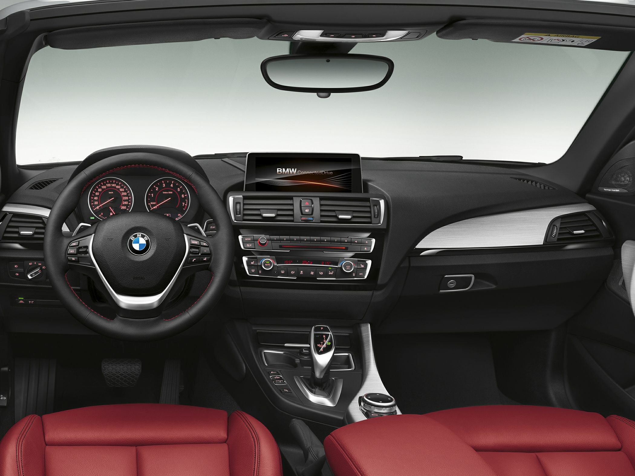 Car interior dashboard with steering wheel and center console controls.