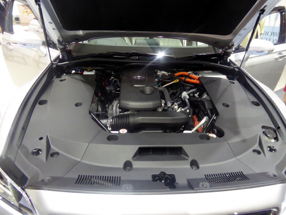 Engine bay with covered hybrid engine and visible orange high-voltage cables