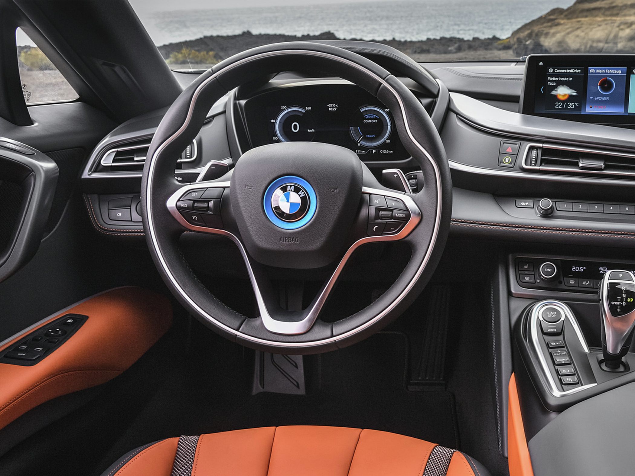 Sporty steering wheel with digital instrument cluster and infotainment screen.