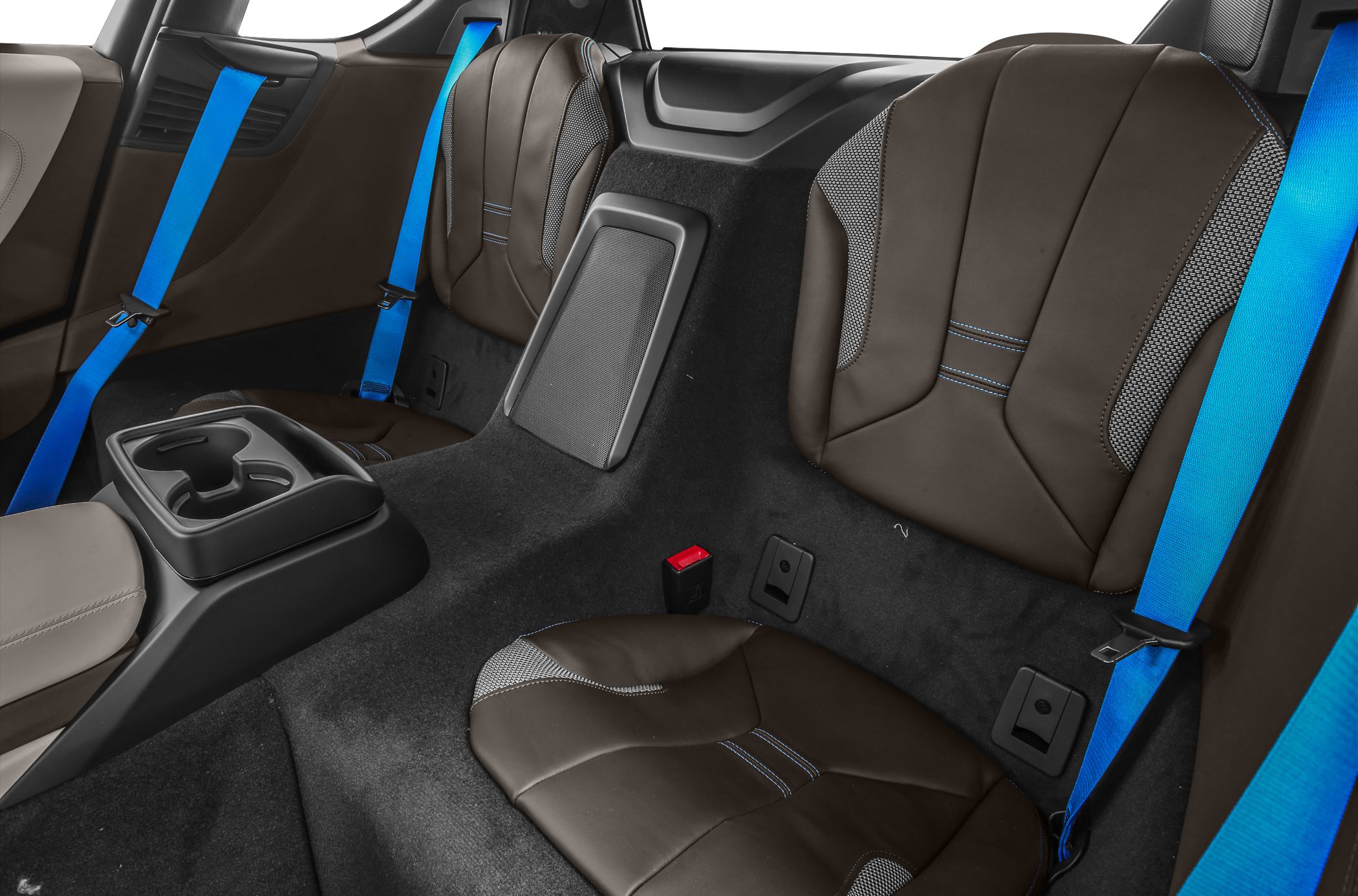 Rear brown leather seats with blue seatbelts in sporty car interior